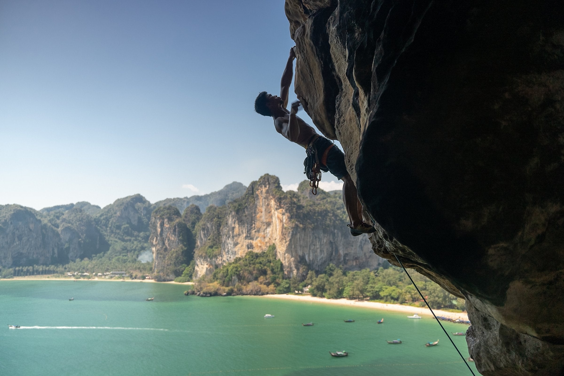 Climber on a limestone overhang above Railay beach, Krabi