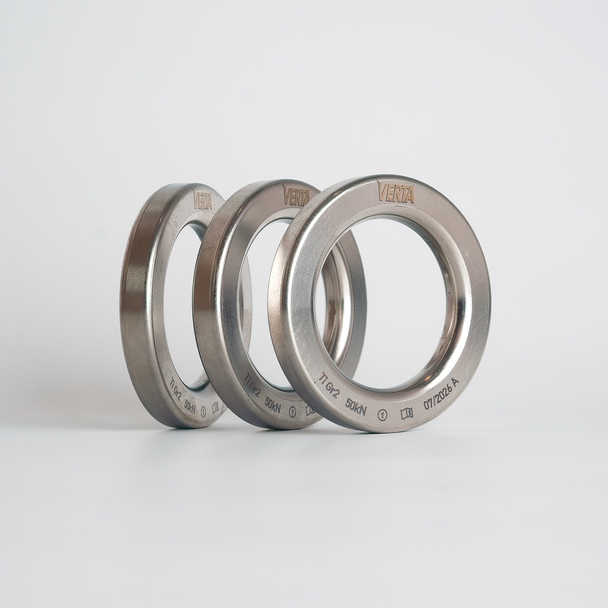 Three forged titanium lower-off rings showing the continuous weld-free surface